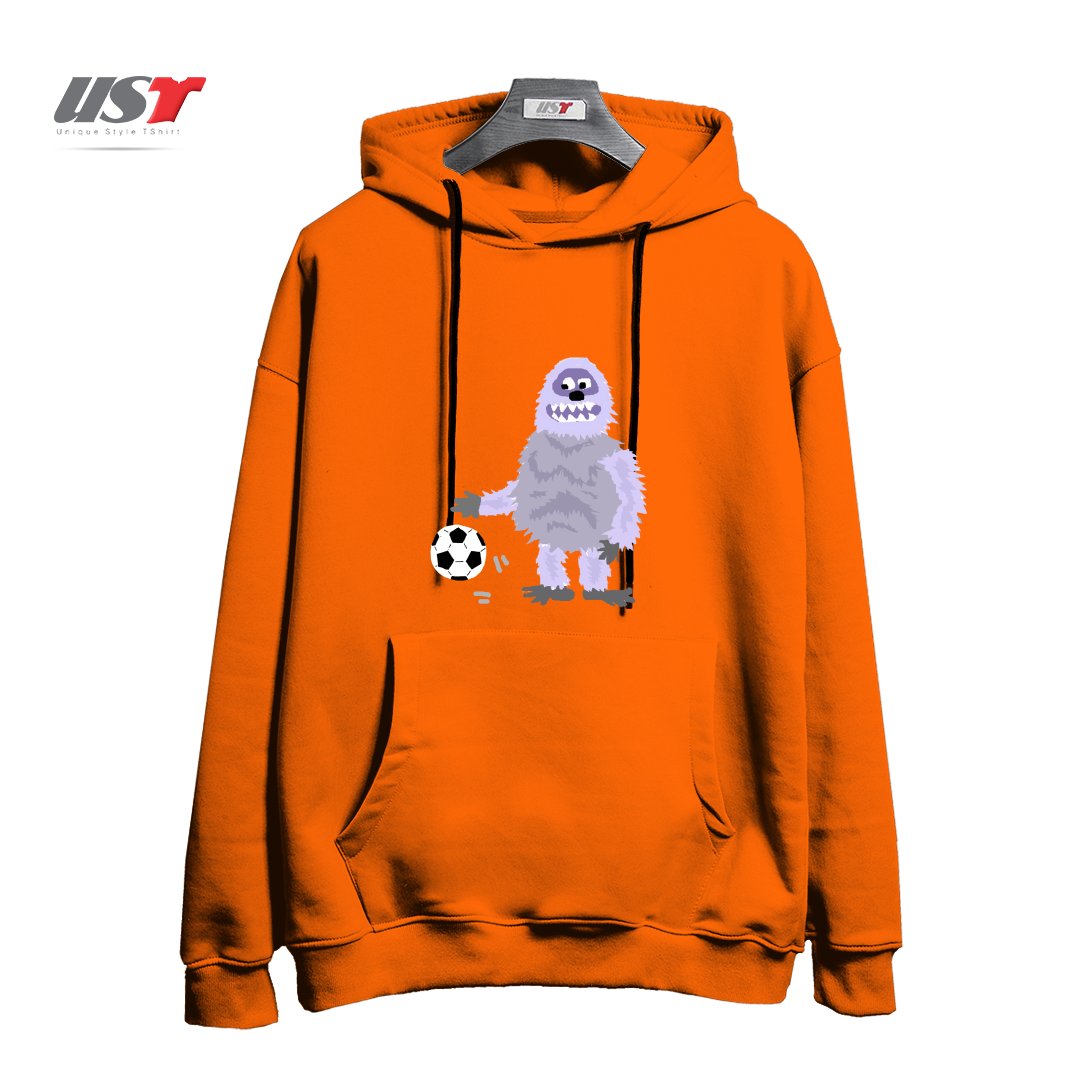 طرح FUNNY ABOMINABLE SNOWMAN PLAYING SOCCER هودی اورسایزرنگ نارنجی